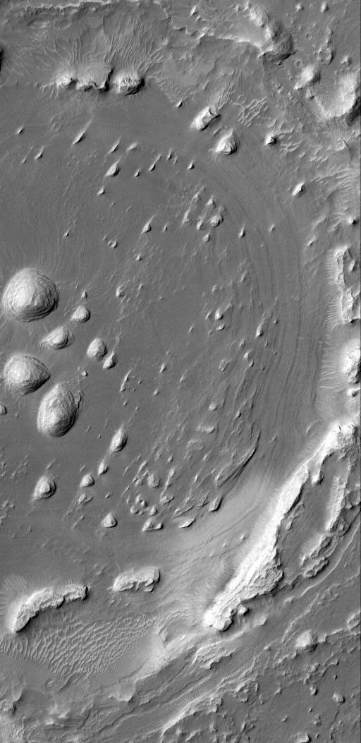 NASA's Mars Global Surveyor shows a portion of an old impact crater that was filled, buried, and is now being exhumed from within sedimentary rock strata located in western Arabia Terra on Mars.