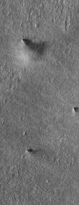 NASA's Mars Global Surveyor shows a group of three large afternoon dust devils occurring within several kilometers of each other in northwestern Amazonis on Mars during the northern summer in November 2004.