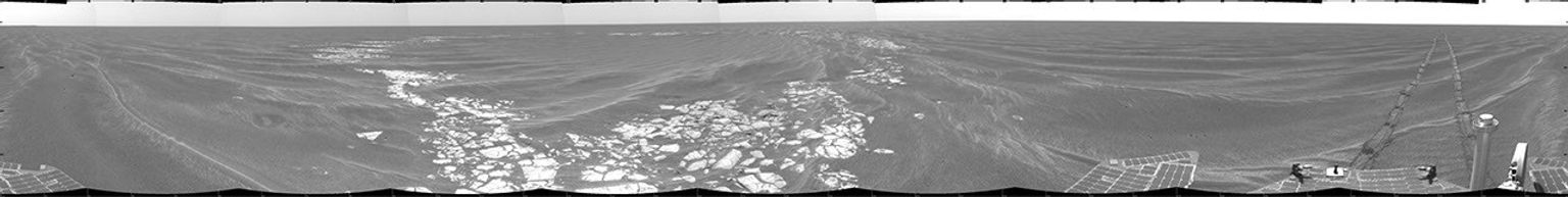 NASA's Mars Exploration Rover Opportunity took this cylindrical projection 360-degree view of the rover's surroundings on March 8, 2005 at Vostok Crater. Much of the crater is buried in sand.