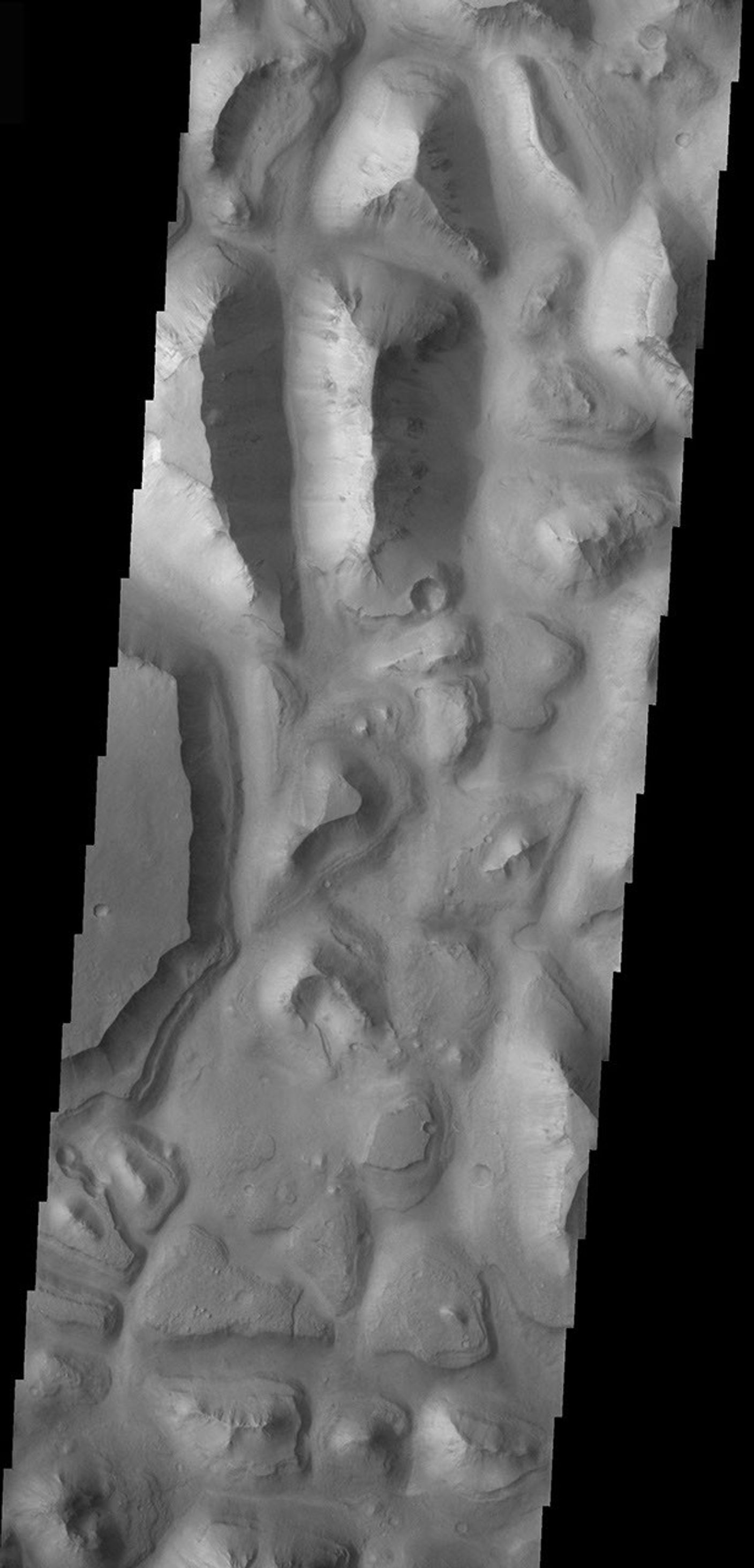 This image taken by NASA's Mars Odyssey shows Eos Chasma which contains a feature type on Mars called a Mensa, from the Latin word for 'table.' A Mensa is a flat-topped prominence with cliff-like edges.