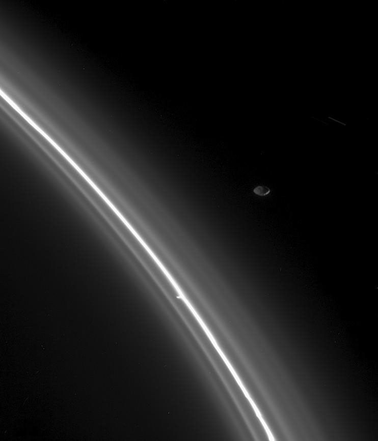 From just outside the faint edge of Saturn's F ring, the moon Pandora keeps watch over her fine-grained flock as seen by NASA's Cassini orbiter.