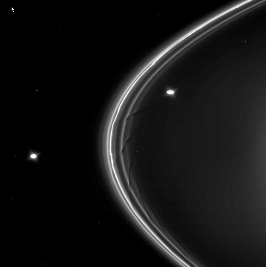 This frame from a movie sequence from NASA's Cassini spacecraft shows dark drapes in the inner strands of Saturn's F ring caused by the gravitational influence of the shepherd moon Prometheus (102 kilometers, or 63 miles across).