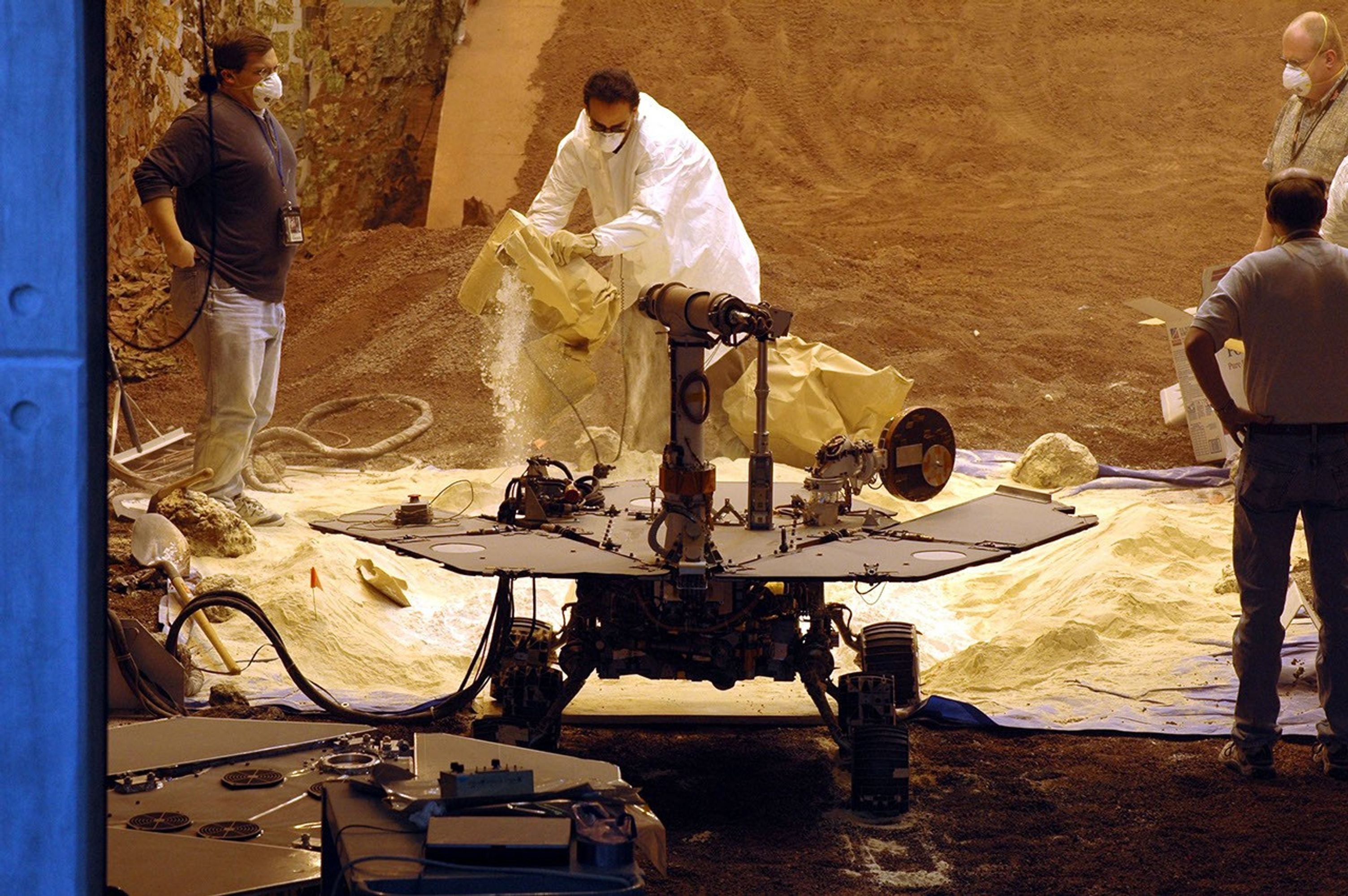 Rover engineers prepare a mixture of sandy and powdery materials to simulate some difficult Mars driving conditions inside a facility at NASA's Jet Propulsion Laboratory, Pasadena, Calif.