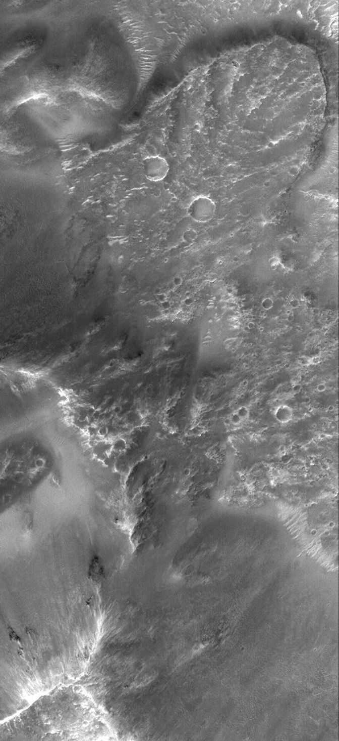 NASA's Mars Global Surveyor shows a tongue of debris at the base of the wall of a large crater in Terra Tyrrhena on Mars. The tongue is the combined product of landsliding and emplacement of crater ejecta.