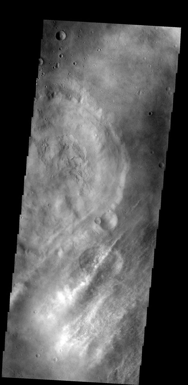 These streamers of clouds cross over a small crater on Mars without deflection as seen by NASA's 2001 Mars Odyssey spacecraft.