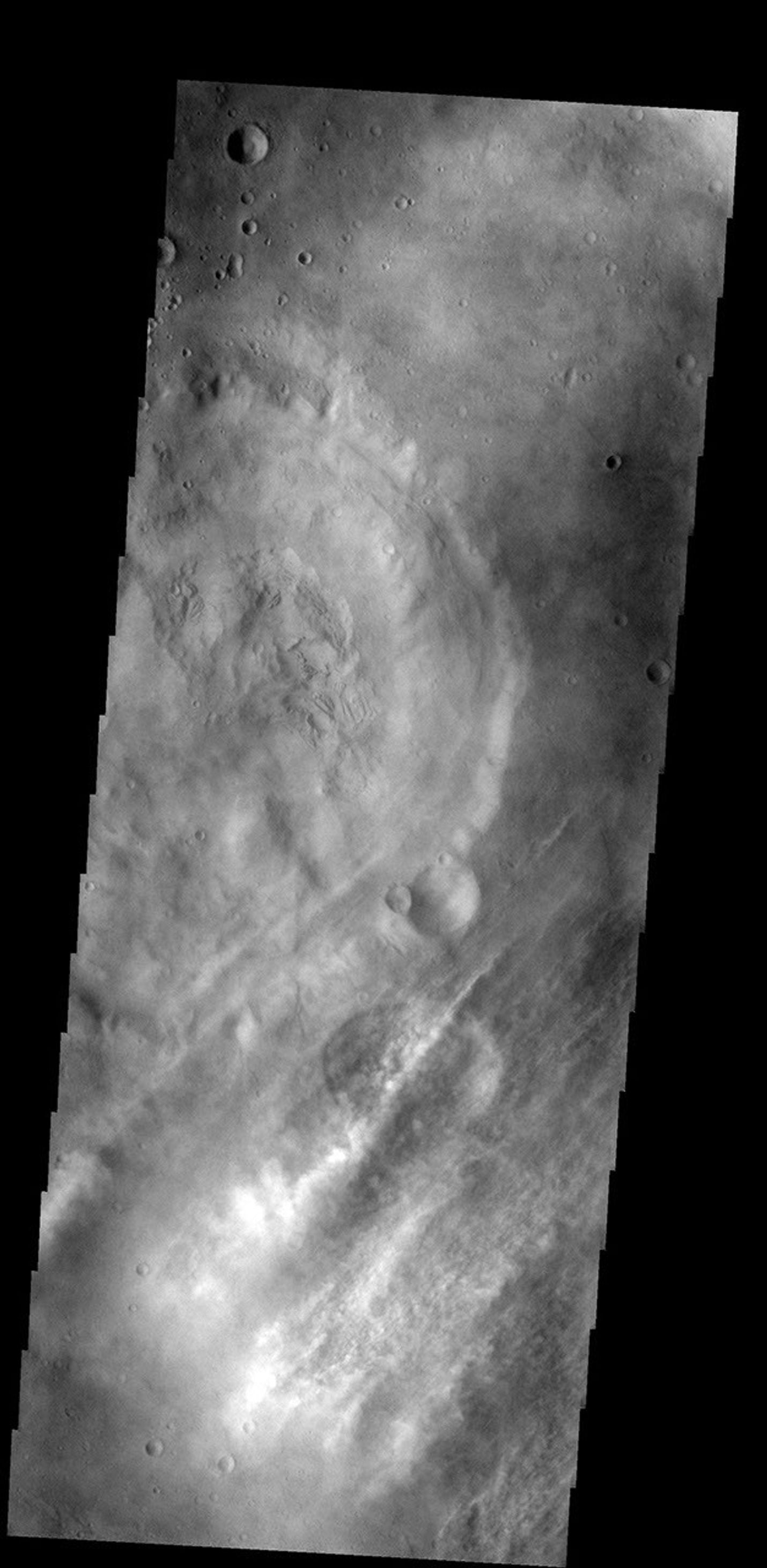 These streamers of clouds cross over a small crater on Mars without deflection as seen by NASA's 2001 Mars Odyssey spacecraft.