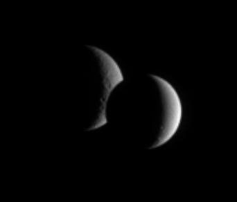 Saturn's Dione and Rhea pair up for an occultation, or mutual event, as seen by NASA's Cassini. While the lit portion of each moon is but a crescent, the dar side of Dione has begun to take a bite out of its distant sibling moon.