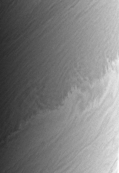 Saturn's restless clouds offer endless complexity, such as this small-scale repeating pattern which is superimposed a larger-scale wavelike modulation of the boundary between a bright zone and a darker belt. This image is from NASA's Cassini spacecraft.