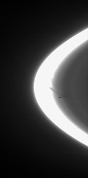 Prometheus zooms across NASA's Cassini spacecraft's field of view, attended by faint streamers and deep gores in the F ring. This frame from a movie sequence of five images shows the F ring shepherd moon shaping the ring's inner edge.