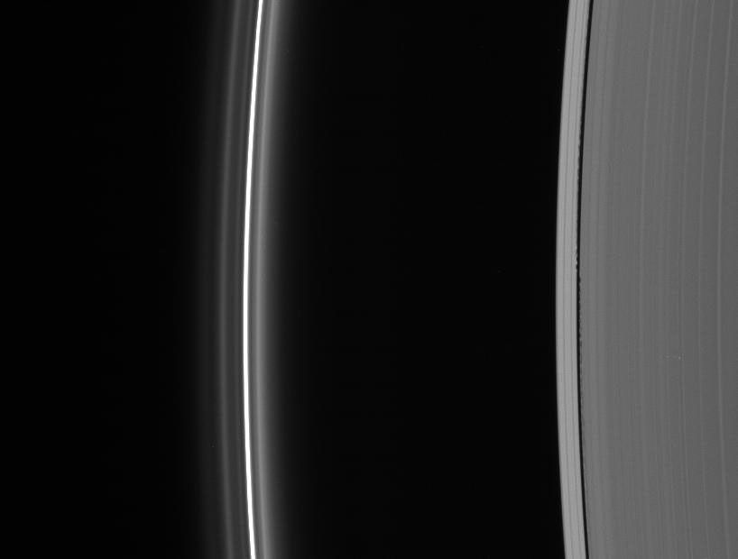 Edge waves in the Keeler Gap betray the presence of the embedded moon Daphnis. At left lies the brilliant F ring with its flanking strands as seen by NASA's Cassini spacecraft.