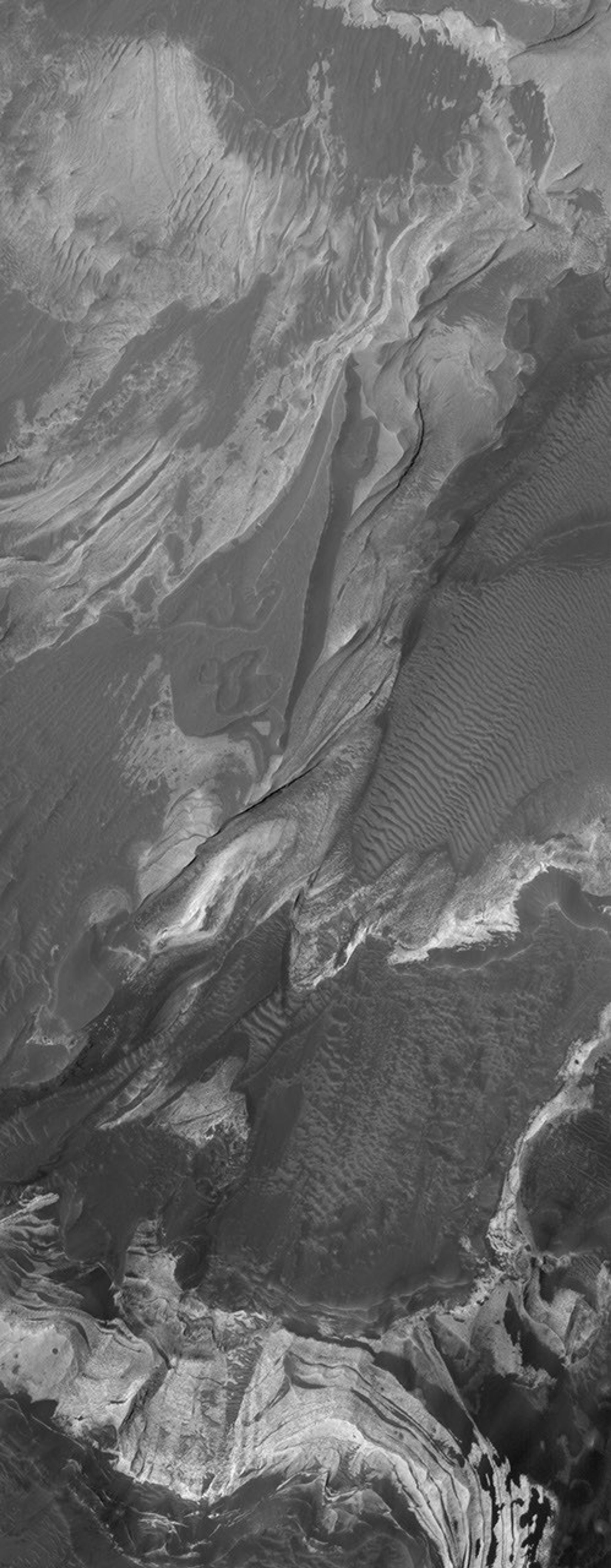 NASA's Mars Global Surveyor shows layered, light-toned, sedimentary rocks that have been exposed by erosion in Coprates Chasma, one of the many chasms which comprise the Valles Marineris trough system on Mars.