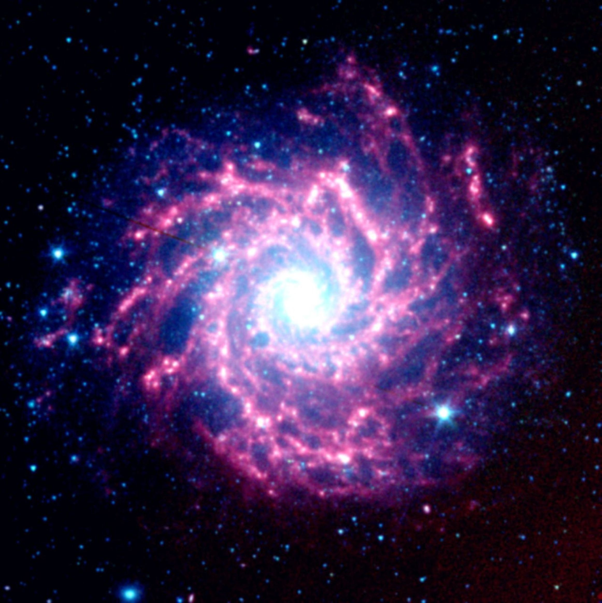 Astronomers using NASA's Spitzer Space Telescope have spotted a 'dust factory' 30 million light-years away in the spiral galaxy M74. The factory is located at the scene of a massive star's explosive death, or supernova.