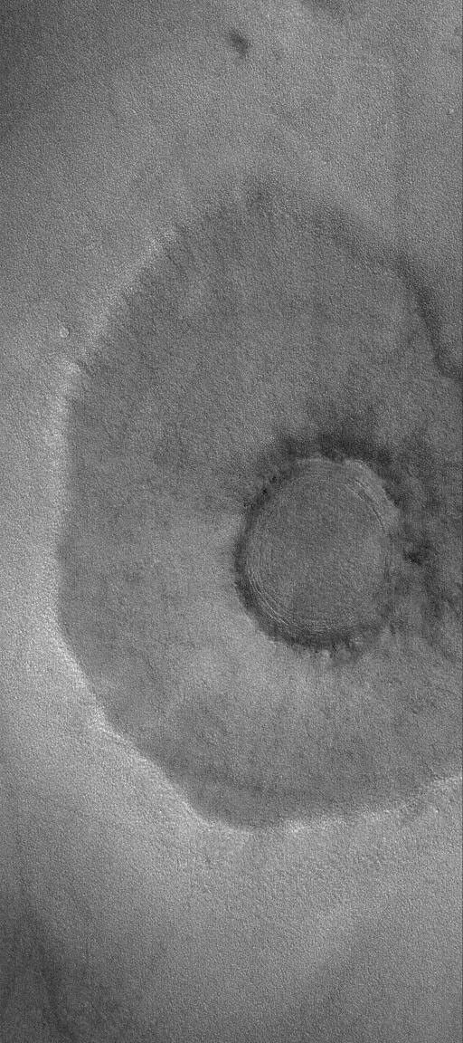 This image from NASA's Mars Global Surveyor shows a pedestal a 'pancake' or 'pedestal' crater on the martian northern plains. The rocky ejecta from the crater protected the underlying material from being stripped away by wind.