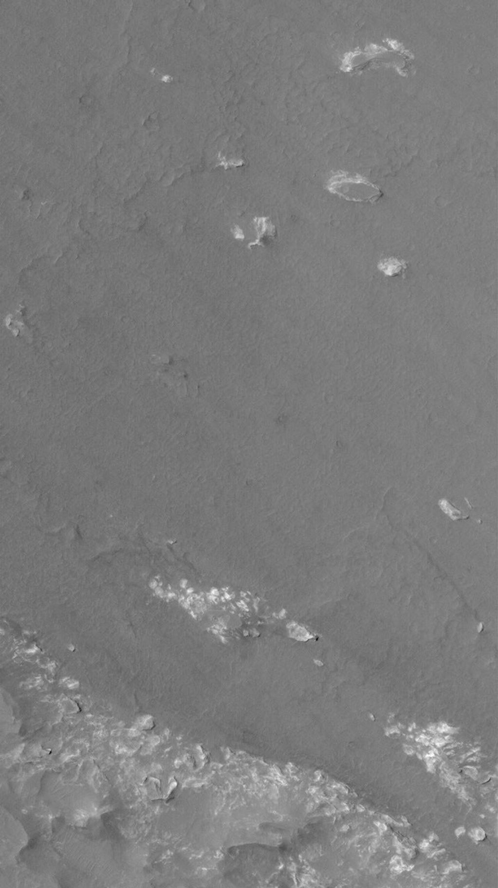 NASA's Mars Global Surveyor shows the contact between an area of light-toned rock and an expanse of darker-toned materials on the floor of Coprates Chasma on Mars.