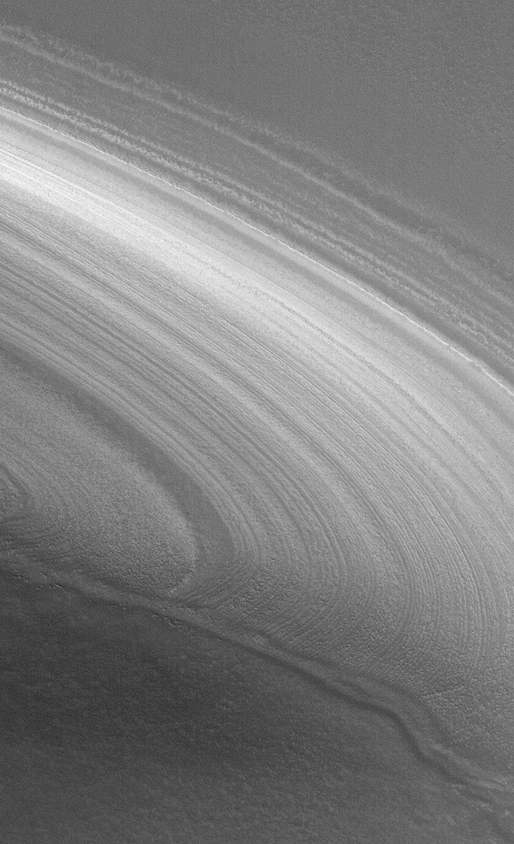 NASA's Mars Global Surveyor shows a layered slope in the martian north polar region, being exposed by the removal of an overlying, smoother material seen in the lower third of the image.