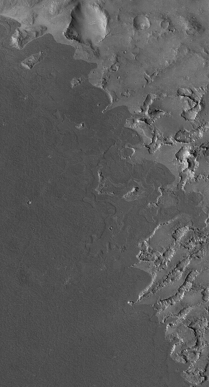 This image from NASA's Mars Global Surveyor shows dark lava flows that have embayed -- flowed up against and into -- higher, more rugged terrain in the Cyclopia/Aethiopis region of Mars (southwest of Cerberus).