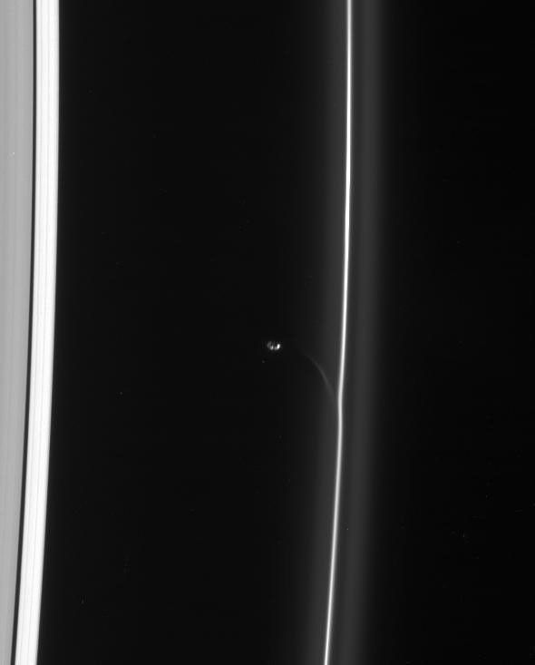 Saturn's shepherd moon Prometheus draws a fresh streamer of material from the F ring as it passes the ring's interior edge as seen by NASA's Cassini spacecraft.
