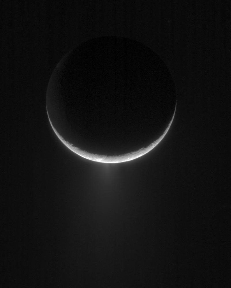 Peeking over the crescent of Saturn's moon Enceladus, NASA's Cassini spacecraft views the towering plume of ice particles erupting from the moon's south polar region