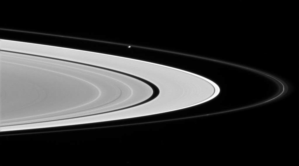 Prometheus glides across the scene from left to right, sculpting and perturbing particles in Saturn's F ring. This image was taken in visible light with NASA's Cassini spacecraft's wide-angle camera on June 28, 2007.
