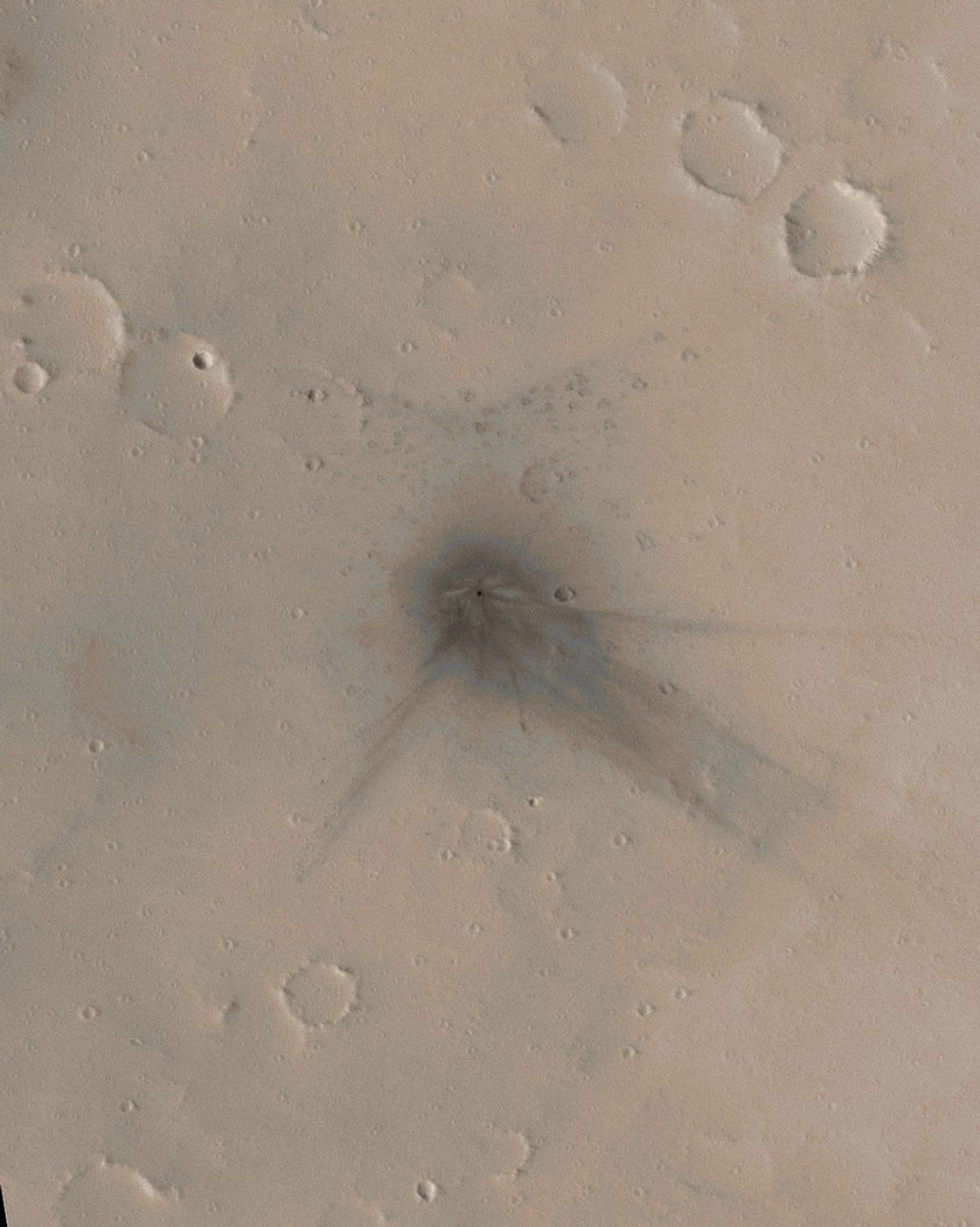 NASA's Mars Global Surveyor shows the north flank of the Martian volcano Ulysses Patera on Mars. Fine details are evident at the impact site, showing how the blast moved dust around and interacted with craters and other small obstacles on the ground.