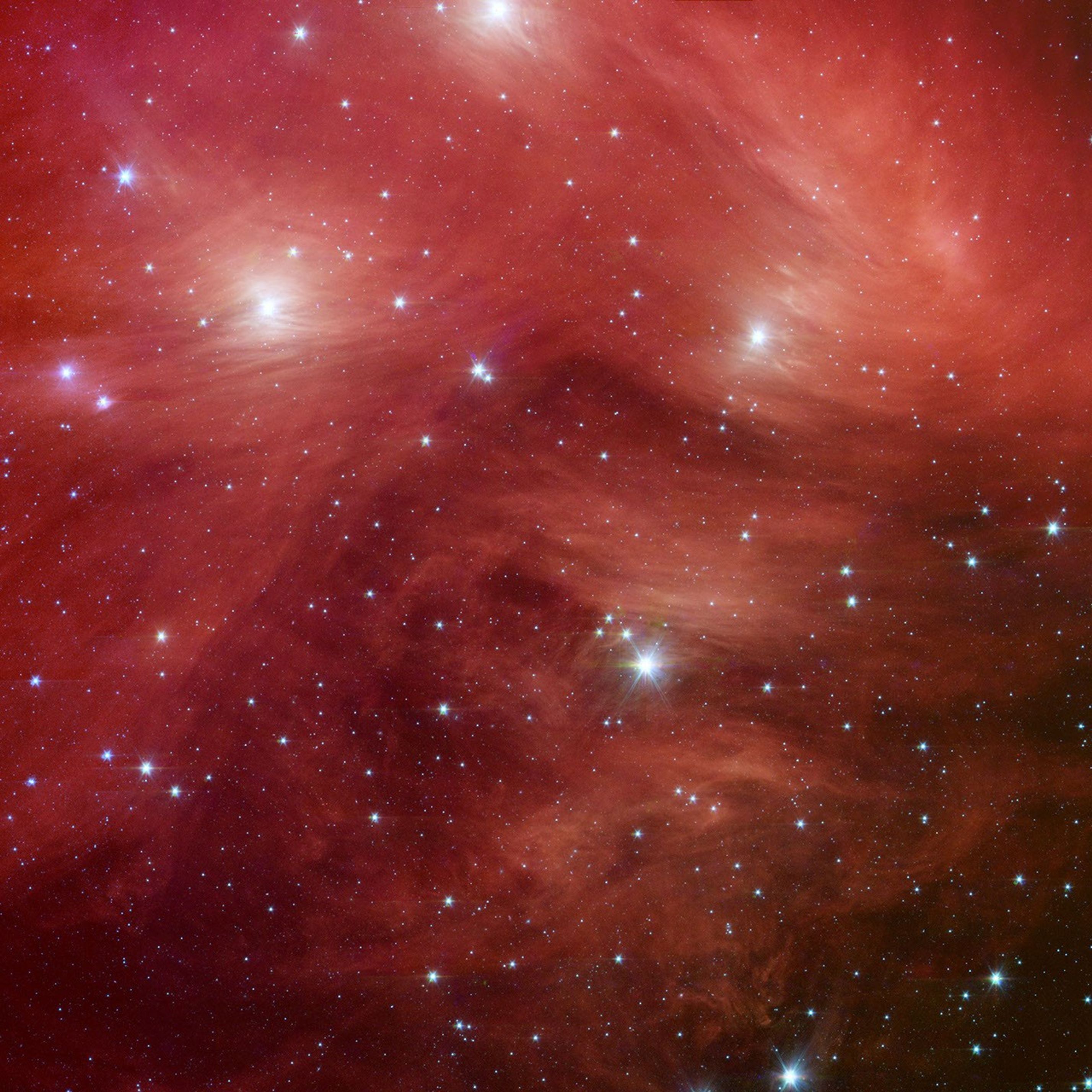 The Seven Sisters, also known as the Pleiades star cluster, seem to float on a bed of feathers in a new infrared image from NASA's Spitzer Space Telescope. Clouds of dust sweep around the stars, swaddling them in a cushiony veil.