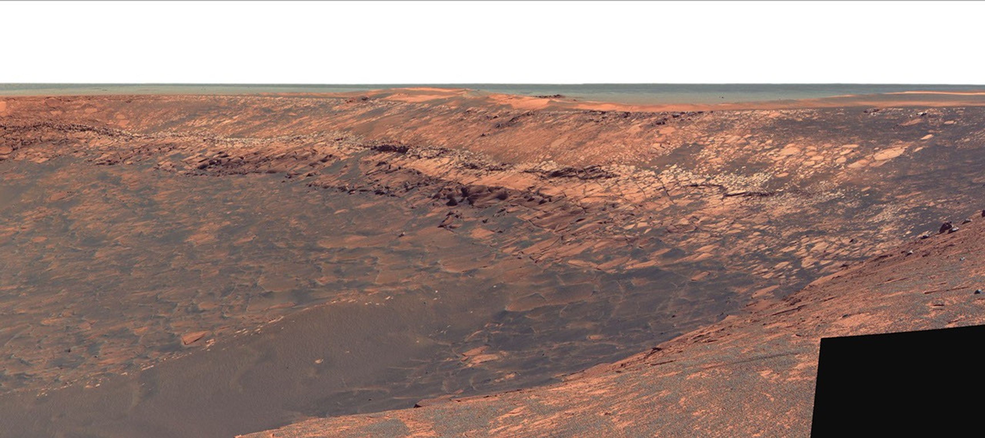 This image shows Duck Bay, an alcove in the rim of Victoria Crater. NASA's Mars Exploration Rover Opportunity rolled down the slopes of Duck Bay in early July 2007 and investigated the rocks inside the crater. A bright band of bedrock lines the upper port