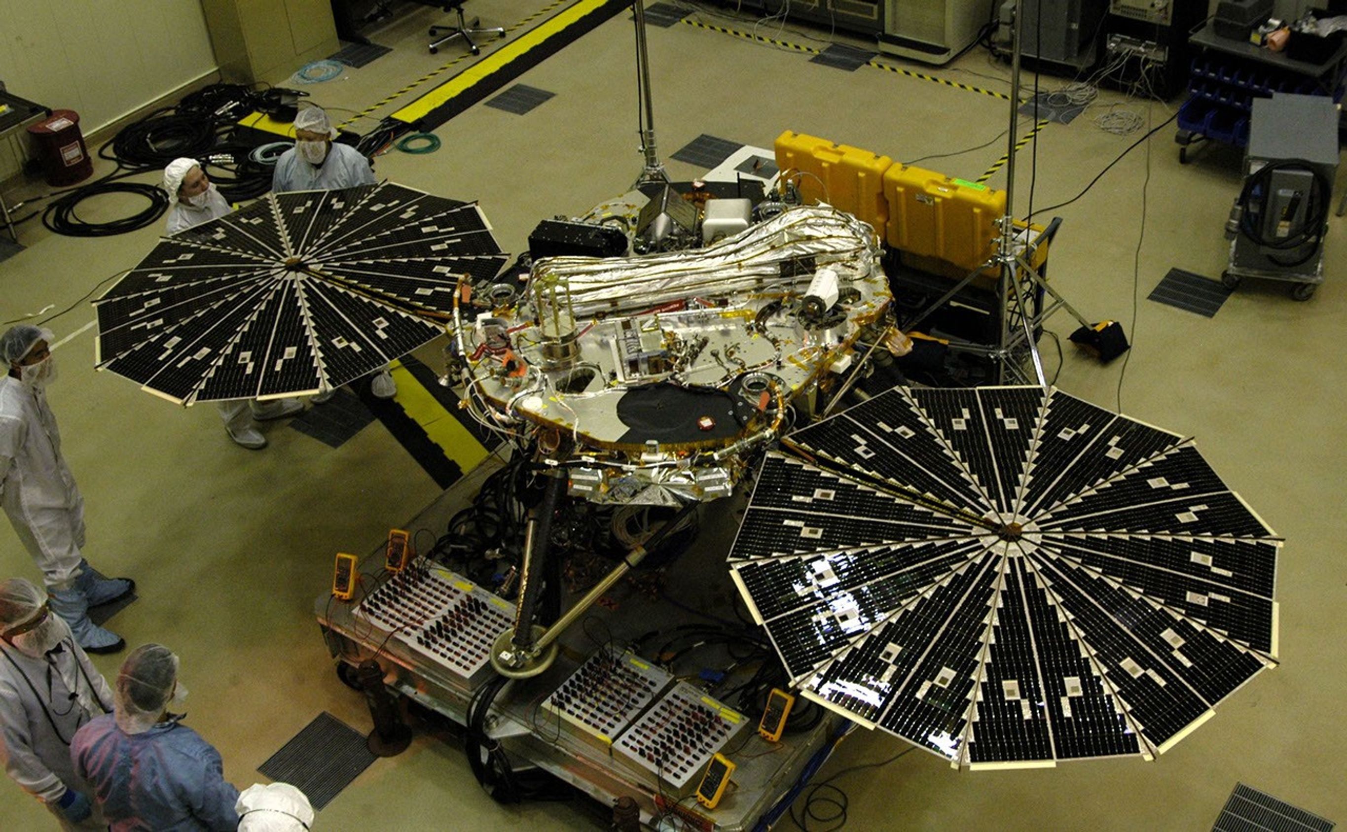 In this photograph of NASA's Phoenix Mars Lander, the spacecraft specialists worked on the lander after its fan-like circular solar arrays had been spread open for testing.