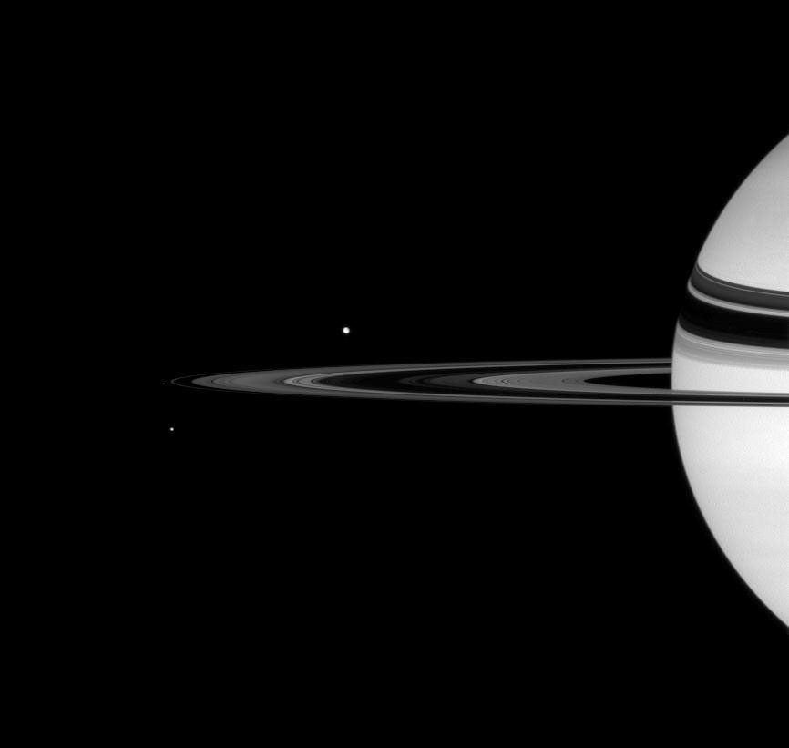 Saturn looks on as Tethys, Pandora, and Mimas round the rings in this image taken by NASA's Cassini spacecraft on Oct. 6, 2007.