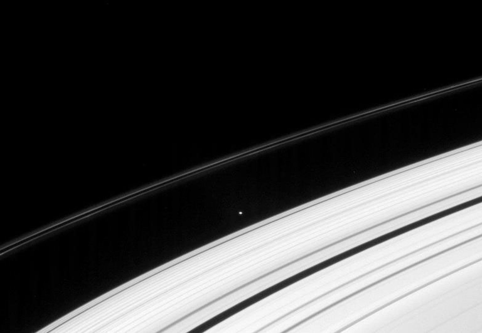 This image taken by NASA's Cassini spacecraft on Dec. 8, 2007, shows the small moon Atlas clinging to the edge of Saturn's A ring. External to the moon is the thin and contorted F ring.