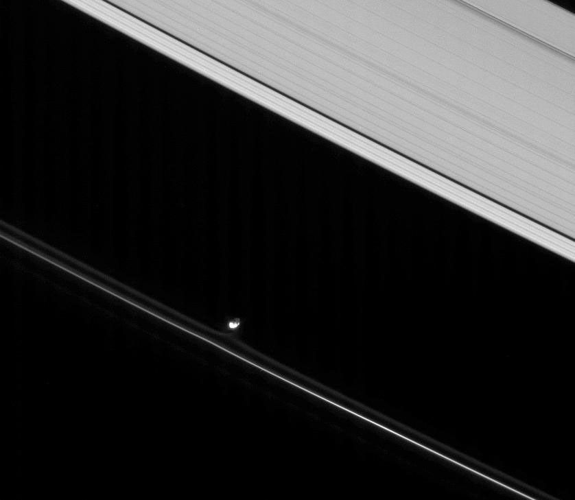 Prometheus, lit partly by direct sunlight and partly by saturnshine, pulls at material in the inner portion of the F ring. Saturnshine is reflected sunlight, often brightening the night sides of Saturn's moons in this image from NASA's Cassini spacecraft.