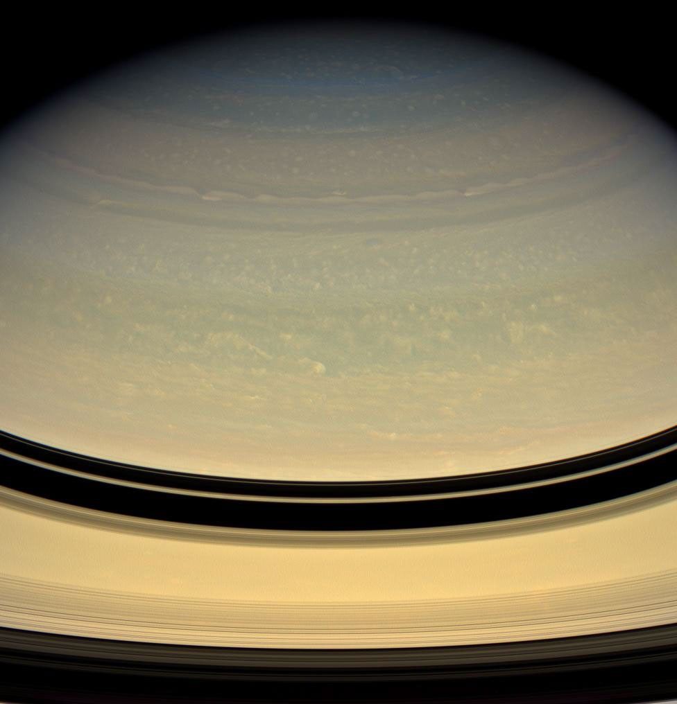Bright puffs and ribbons of cloud drift lazily through Saturn's murky skies. Saturn's clouds are overlain by a thick layer of haze in this image of pastel shades of yellow and blue from NASA's Cassini oribter taken on Apr. 15, 2008.