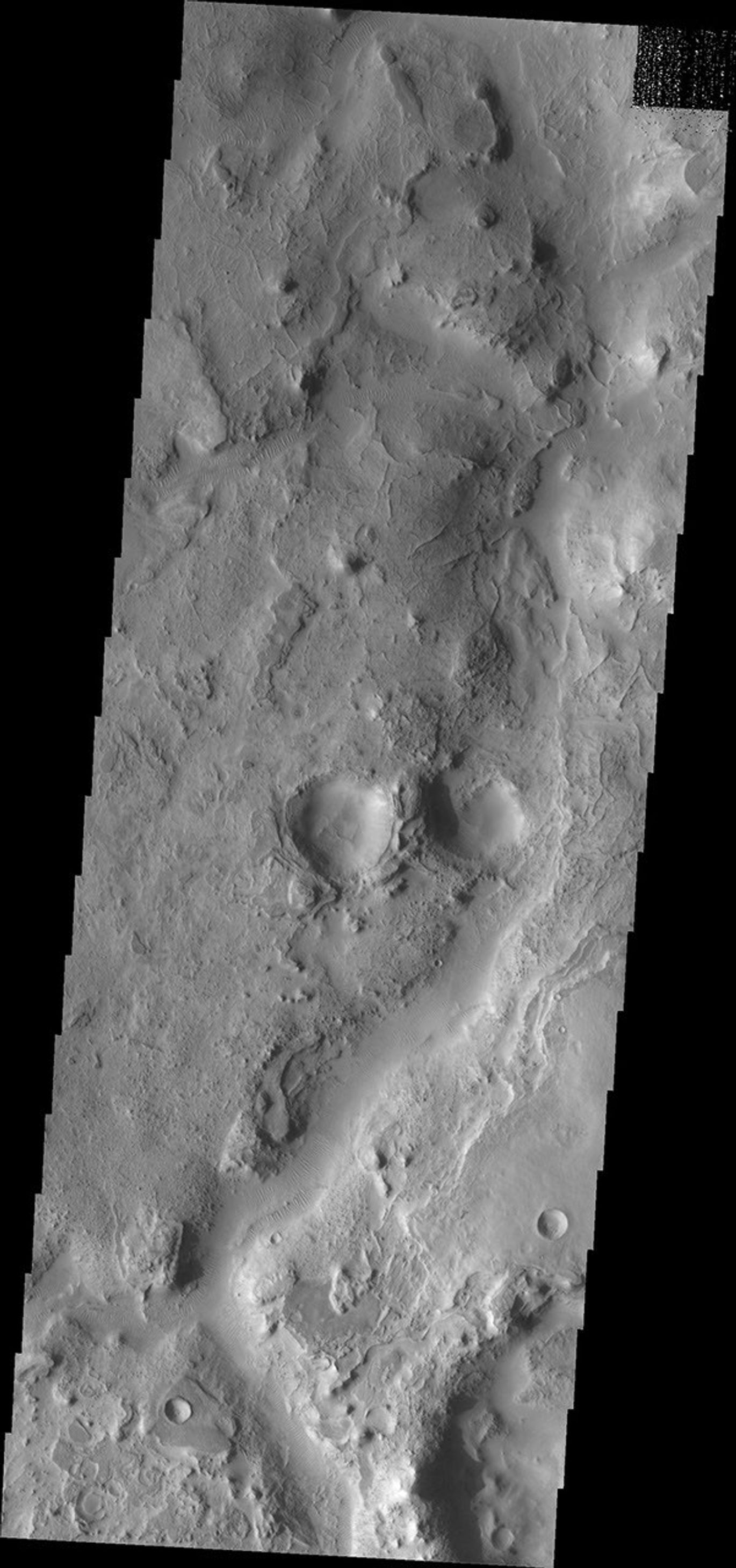 This image from NASA's Mars Odyssey shows transverse dunes and narrow ridges found near the channel of Huo Hsing Vallis on Mars.