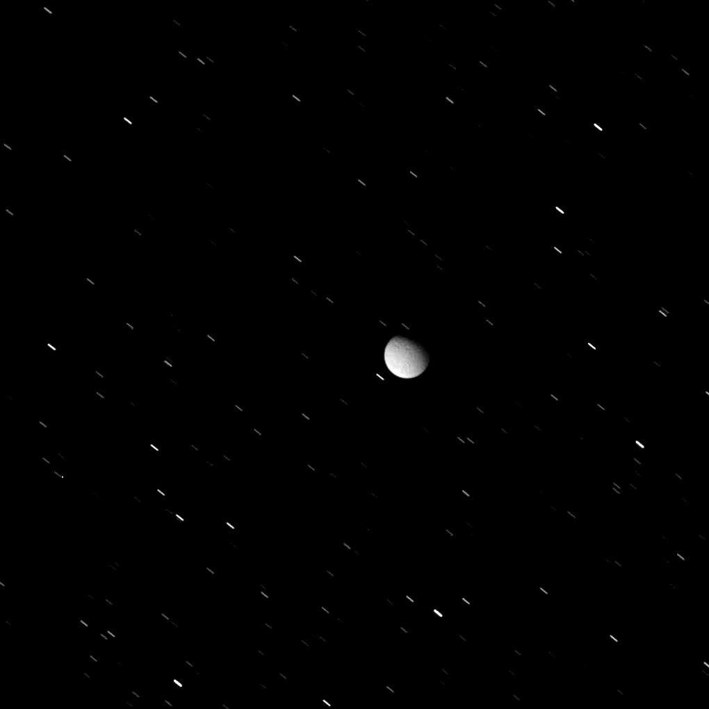 Tethys appears here, against a background of star trails, in a view acquired as the icy moon exited Saturn's shadow. This image was taken in visible light with NASA's Cassini spacecraft's wide-angle camera.
