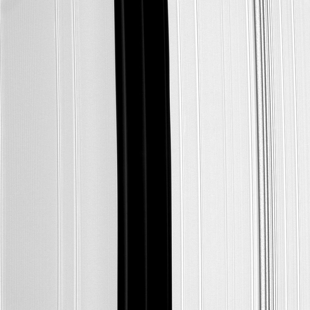The Encke Gap, the broad, vertical dark band running down the center of this image from NASA's Cassini spacecraft, is maintained by the small moon Pan (not pictured). Pan also shepherds three ringlets which appear here as faint, narrow bands.