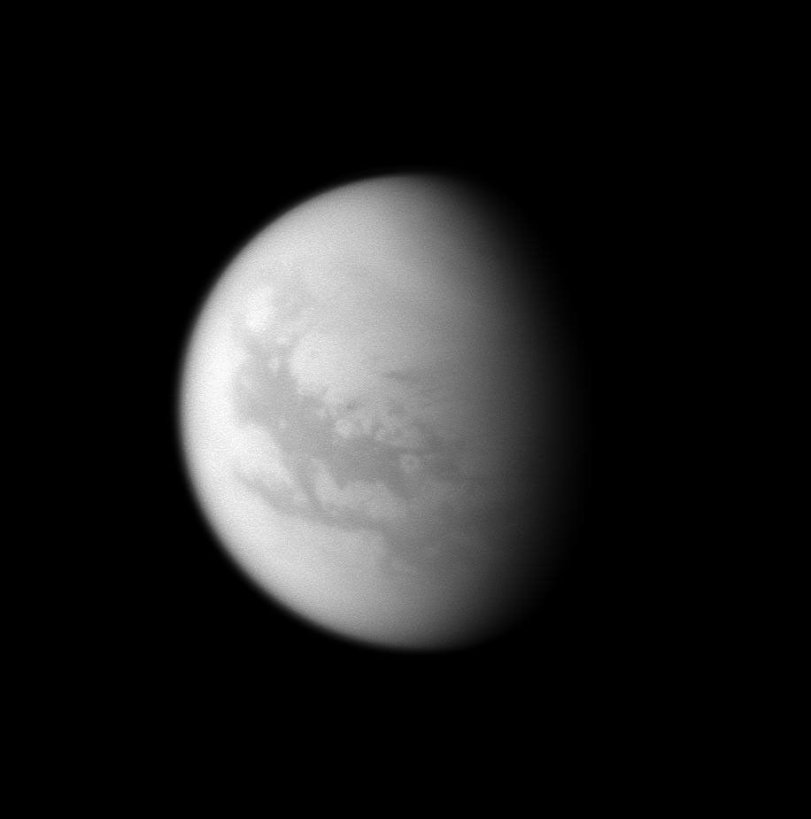 Two dark bands stretch across the moon Titan in this image captured by NASA's Cassini spacecraft: Fensal north of the equator and Aztlan south of the equator. The eastern part of Fensal features the white circle of Bazaruto Facula.