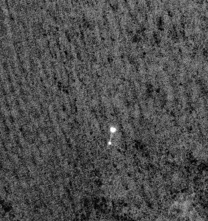 NASA's Phoenix Mars Lander can be seen parachuting down to Mars, in this image captured by the Mars Reconnaissance Orbiter. This is the first time that a spacecraft has imaged the final descent of another spacecraft onto a planetary body.