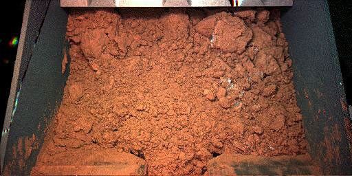 NASA's Phoenix Mars Lander shows material from the martian surface captured by the robotic arm scoop during its first test dig and dump on June 1, 2008. The test sample shown was taken from the digging area informally known as 'Knave of Hearts.'