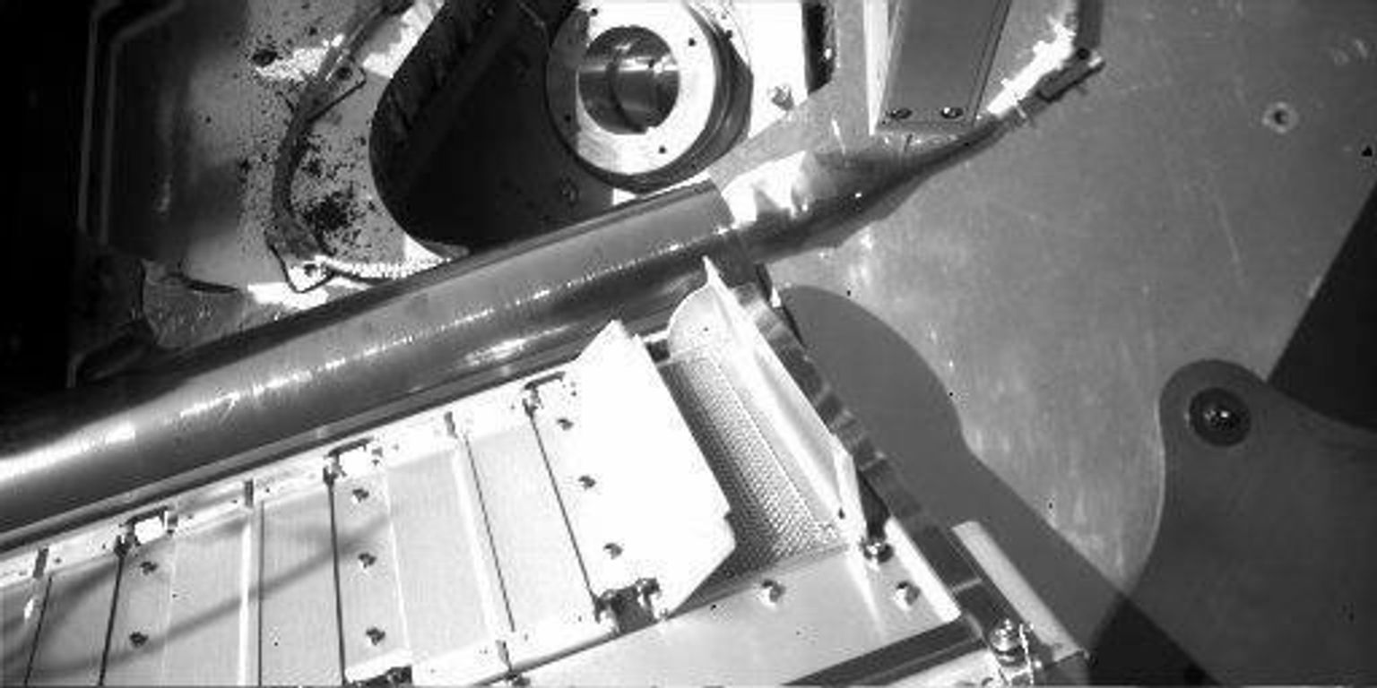 NASA's Phoenix Mars Lander shows partial opening of doors to one of the tiny ovens of itsThermal and Evolved-Gas Analyzer. Each oven has a pair of spring-loaded doors over the opening where a soil sample will be delivered.