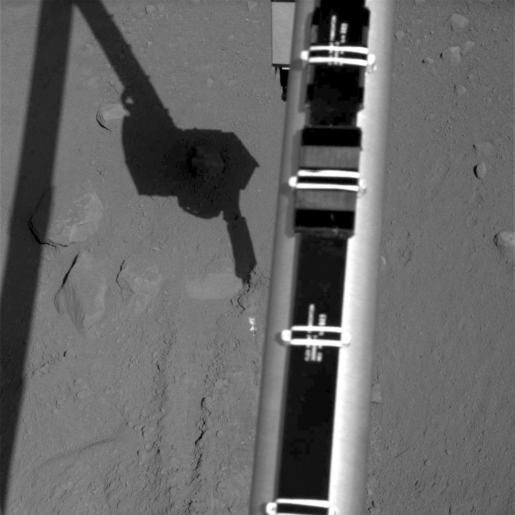 The Surface Stereo Imager on NASA's Phoenix Mars Lander recorded this image of the lander's Robotic Arm enlarging and combining the two trenches informally named 'Dodo' (left) and 'Goldilocks.'