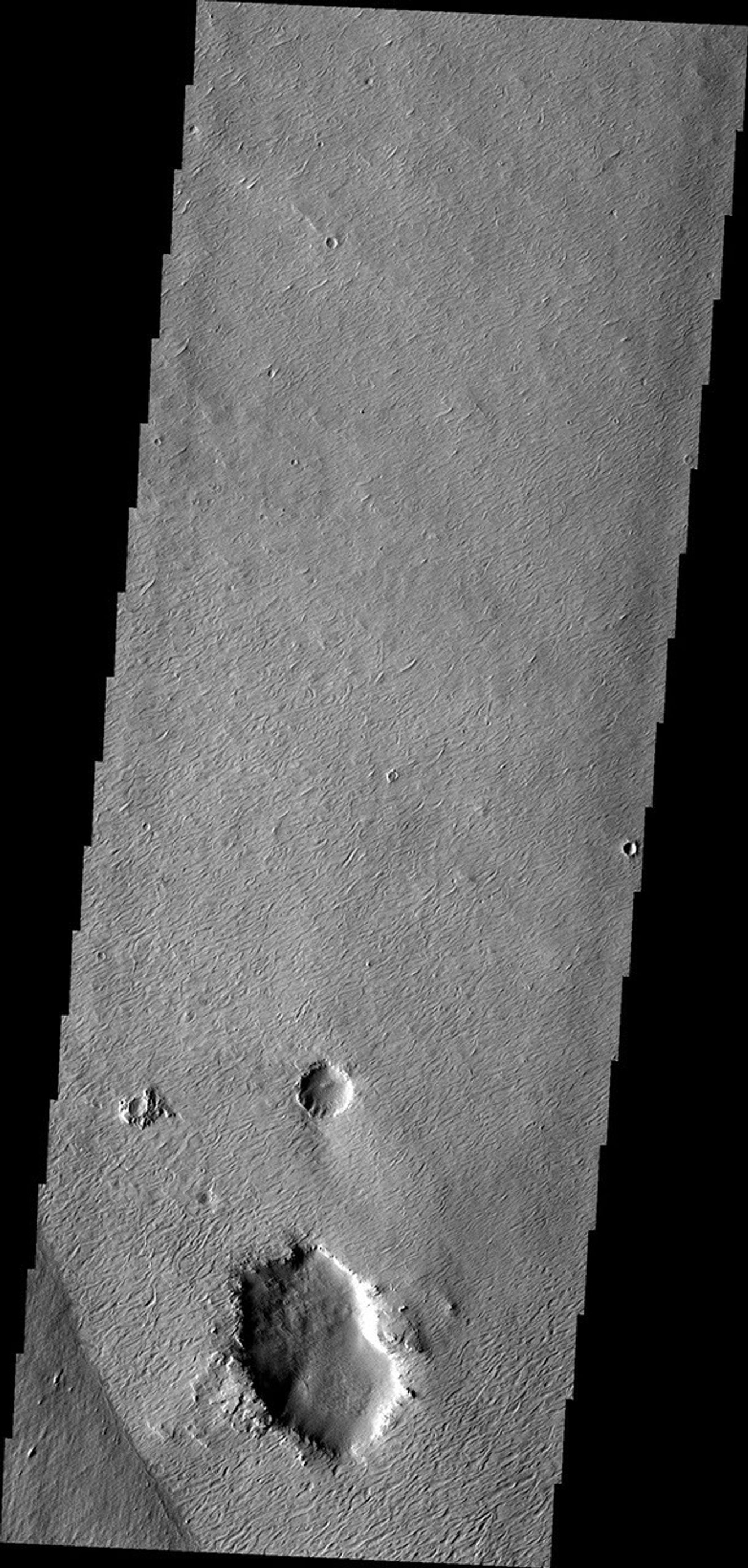This image from NASA's Mars Odyssey shows wind, craters, and an easily eroded material have combined to produce this interesting region of features on Mars.