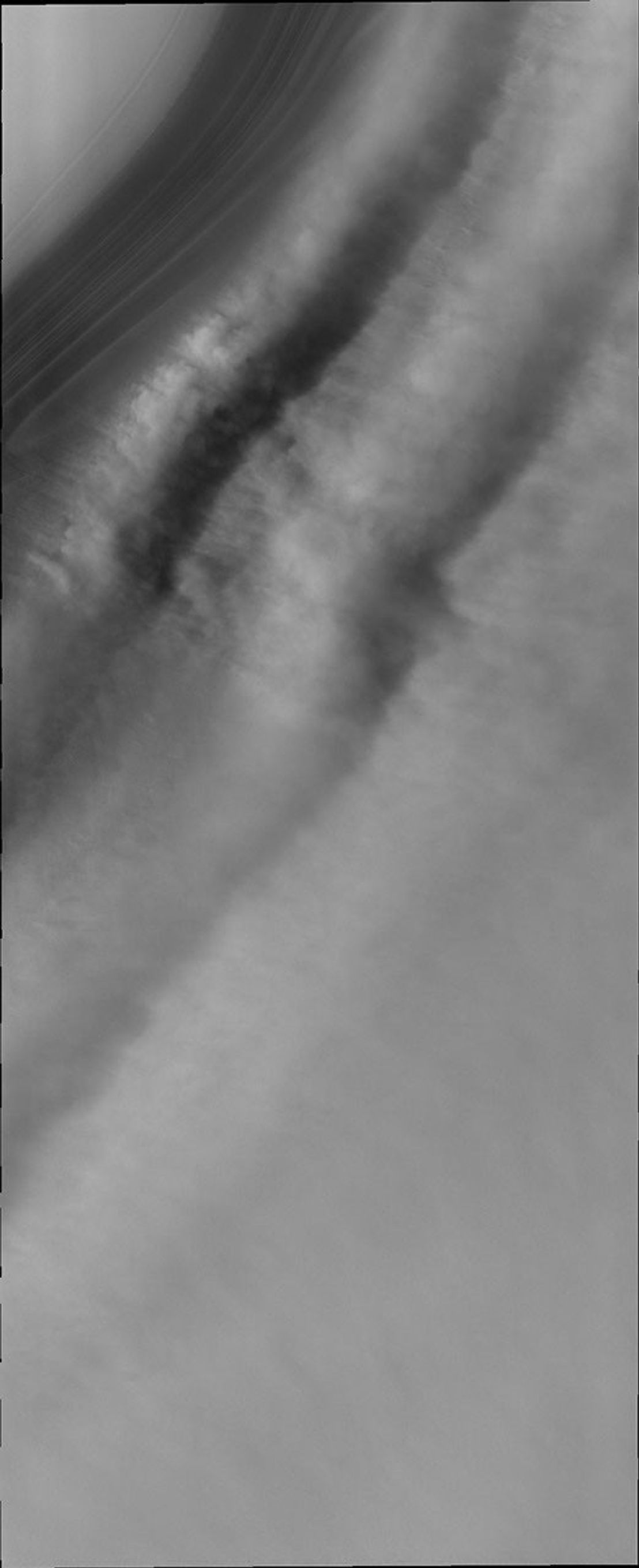 This image from NASA's Mars Odyssey shows winds that have swept across Mars' north polar ice encounter a trough in the ice the laminar flow slows at the base of the trough.
