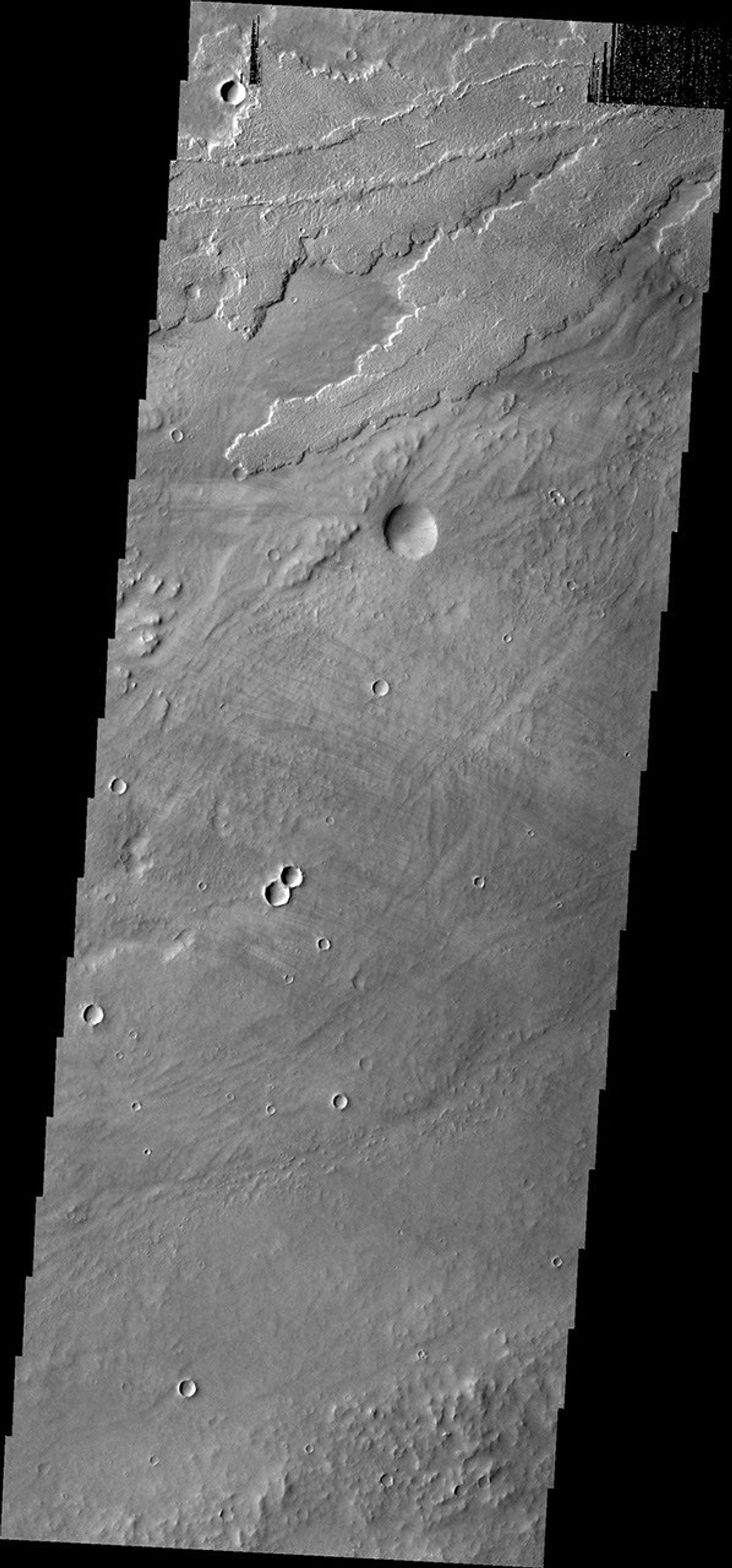 This image from NASA's Mars Odyssey shows many lava flows, part of the extensive Tharsis volcanic complex. These flows appear to originate in the region of Alba Patera and flowed downhill towards Olympus Mons.