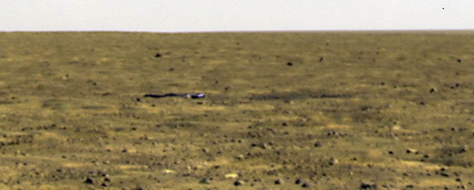 The Phoenix Mars Lander's Surface Stereo Imager took this image of the spacecraft's crumpled heat shield on Sept. 16, 2008. The heat shield lies about halfway between the spacecraft and its backshell/parachute.