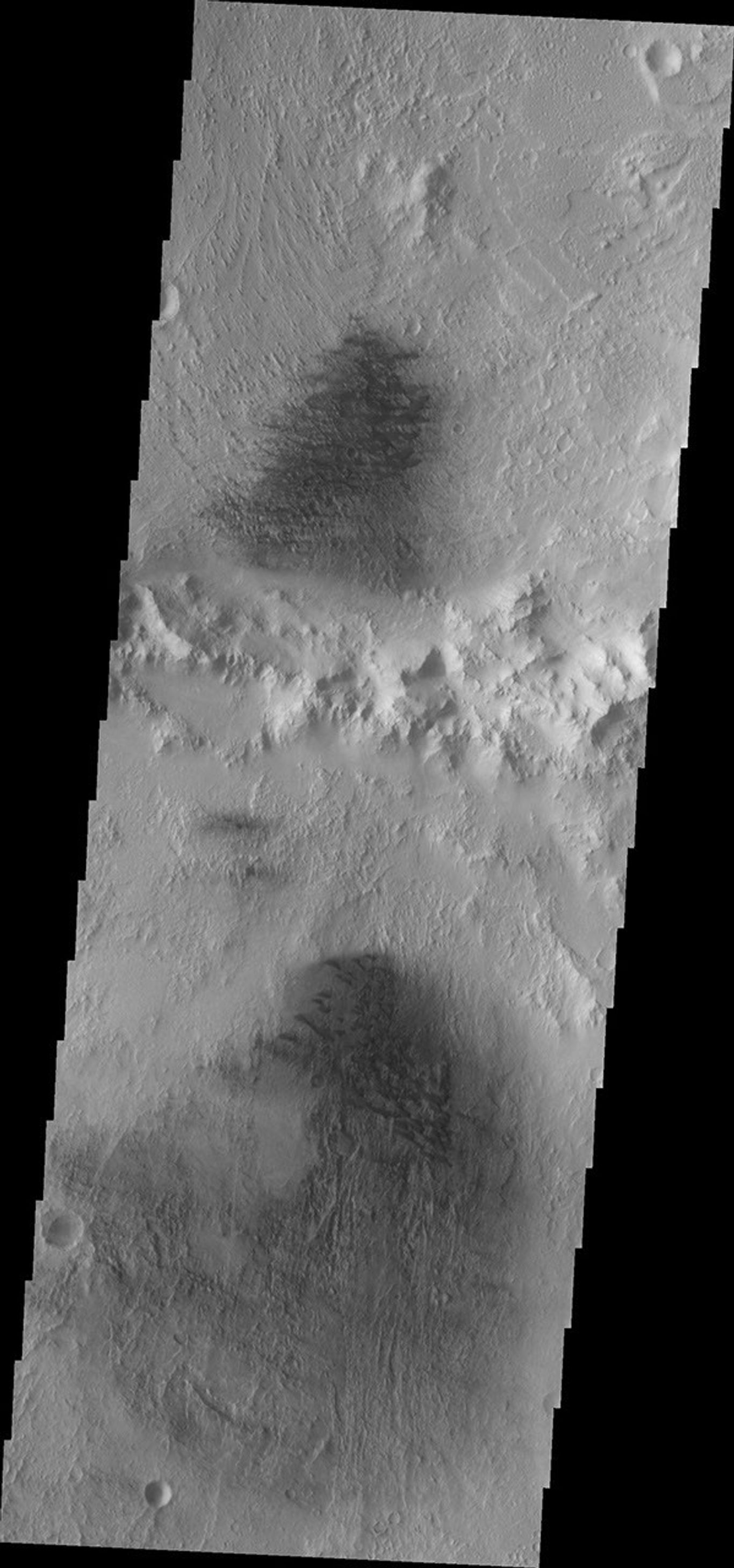 This image from NASA's Mars Odyssey shows the northern part of Du Martheray Crater and the smaller crater on its rim. Both craters have floor features showing evidence of both wind erosion and wind deposition.