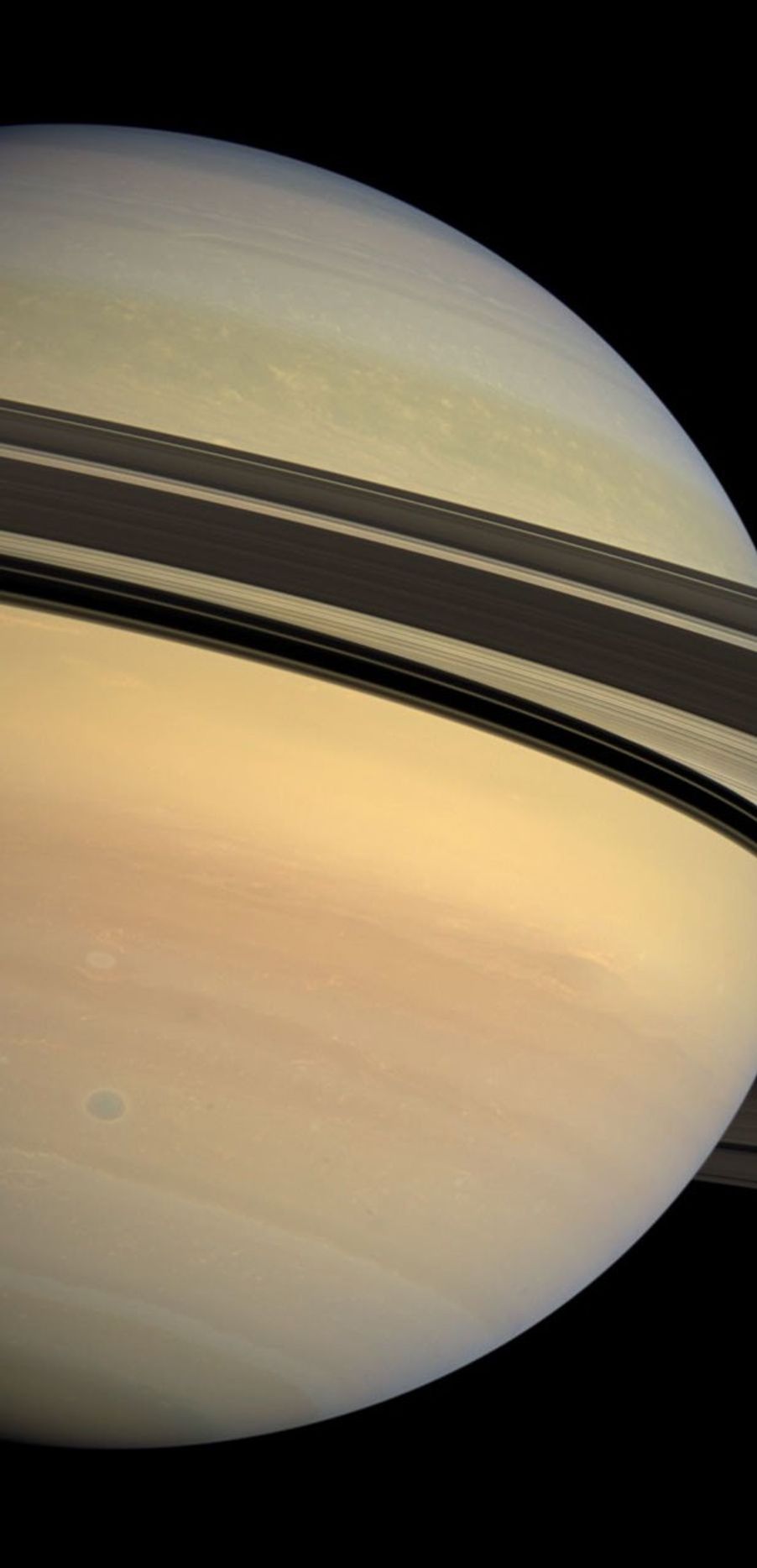 Saturn's rings cast a dramatic shadow separating the blues and greens of the planet's northern hemisphere from the creamy pastels coloring the southern hemisphere. This image was captured by NASA's Cassini spacecraft's wide-angle camera.