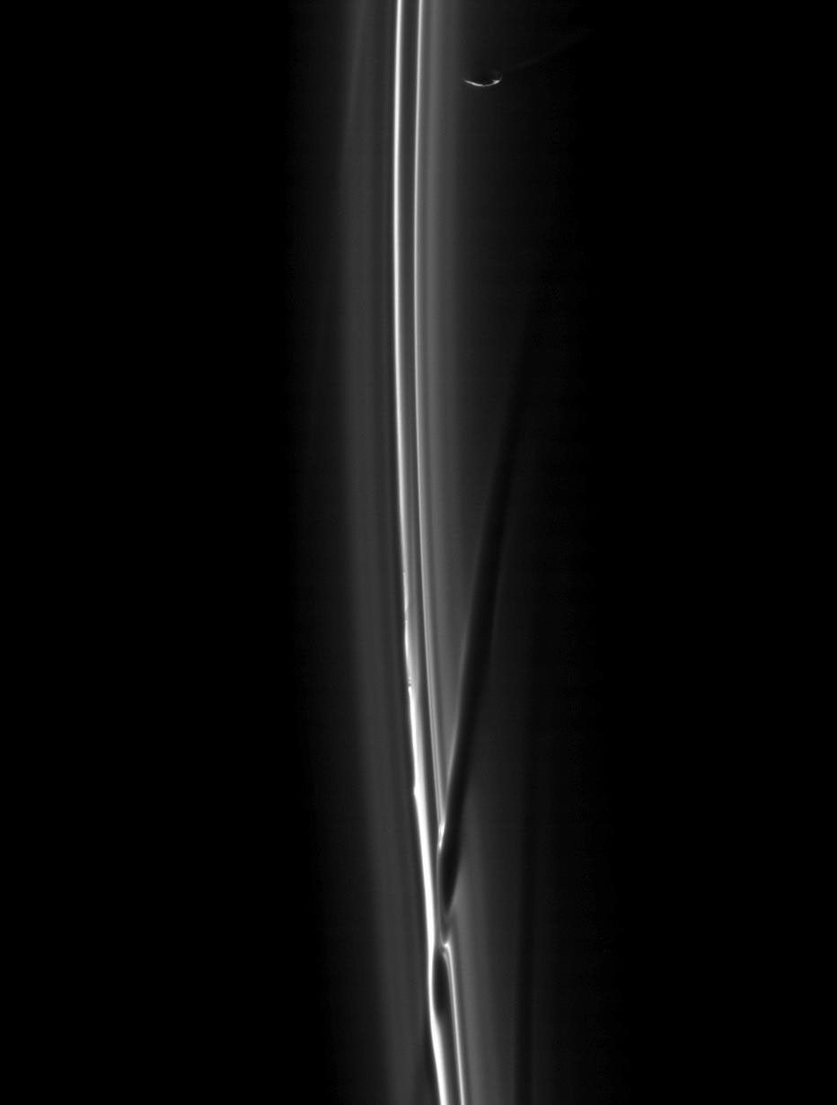 A soft collision between Prometheus and the F ring created the dark channel goring the ring in the bottom of this image from NASA's Cassini spacecraft taken on Feb. 2, 2009.