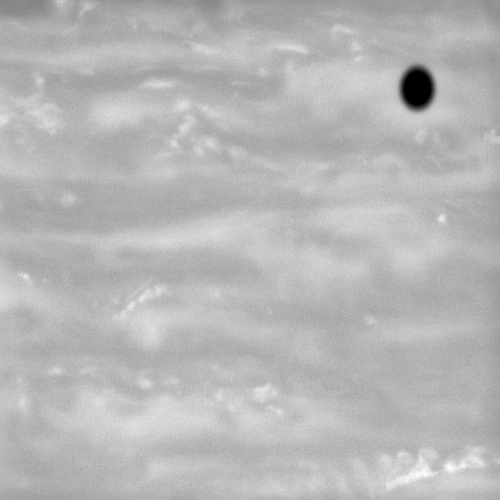 The shadow of Saturn's moon Enceladus cast onto the planet's atmosphere appears like a drop of black ink on a canvas of Saturnian storms. This image was taken by NASA's Cassini spacecraft on June 20, 2008.