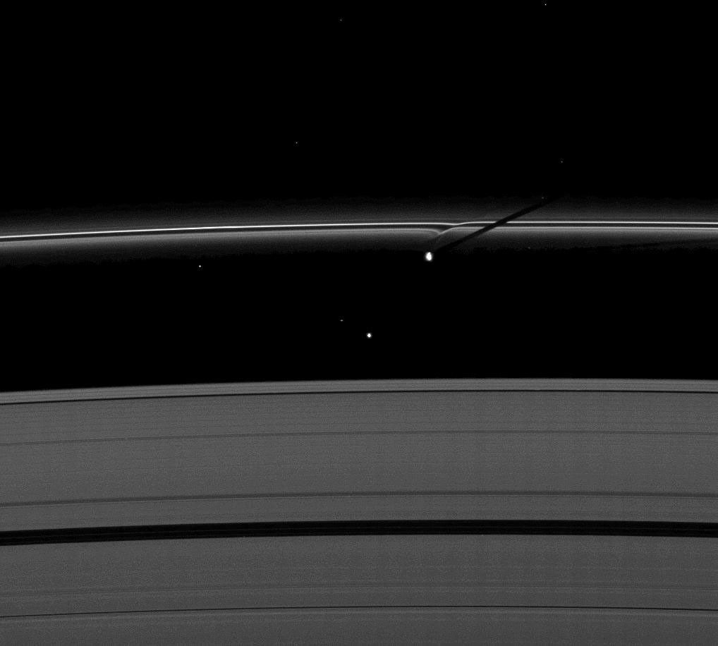 The moon Prometheus casts a shadow on Saturn's F ring near a streamer-channel it has created on the ring. The image was taken by NASA's Cassini spacecraft as the planet approached its August 2009 equinox.