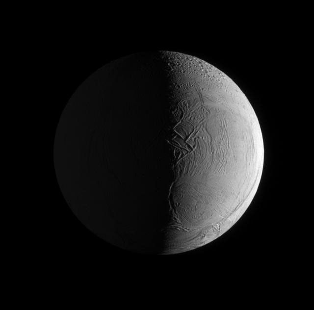 Two sources of light illuminate the textured surface of the moon Enceladus in this image taken by NASA's Cassini spacecraft's narrow angle camera.