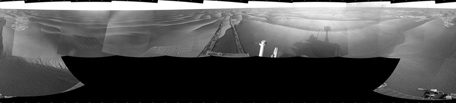 This cylindrical projection image from NASA's Mars Exploration Rover Opportunity shows tracks from the drive extend northward across dark-toned sand ripples and light-toned patches of exposed bedrock in the Meridiani Planum region of Mars.
